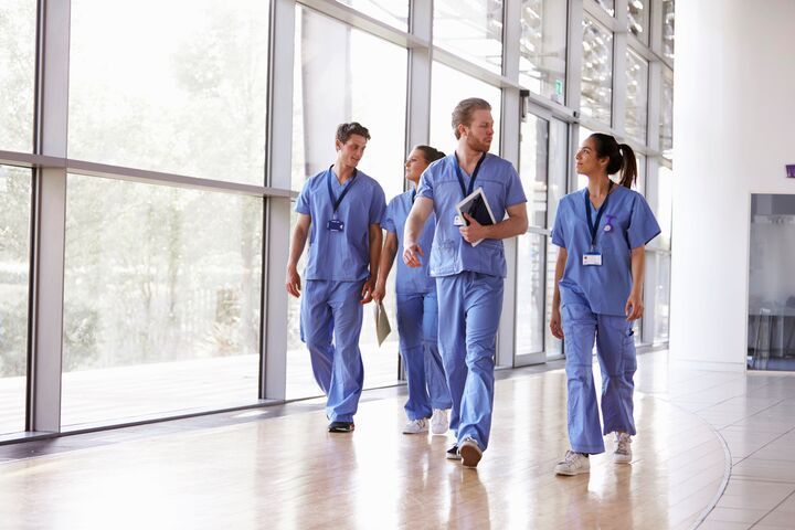 Small-four-healthcare-workers-in-scrubs-walking-in-corri-2021-08-26-16-13-53-utc.jpg