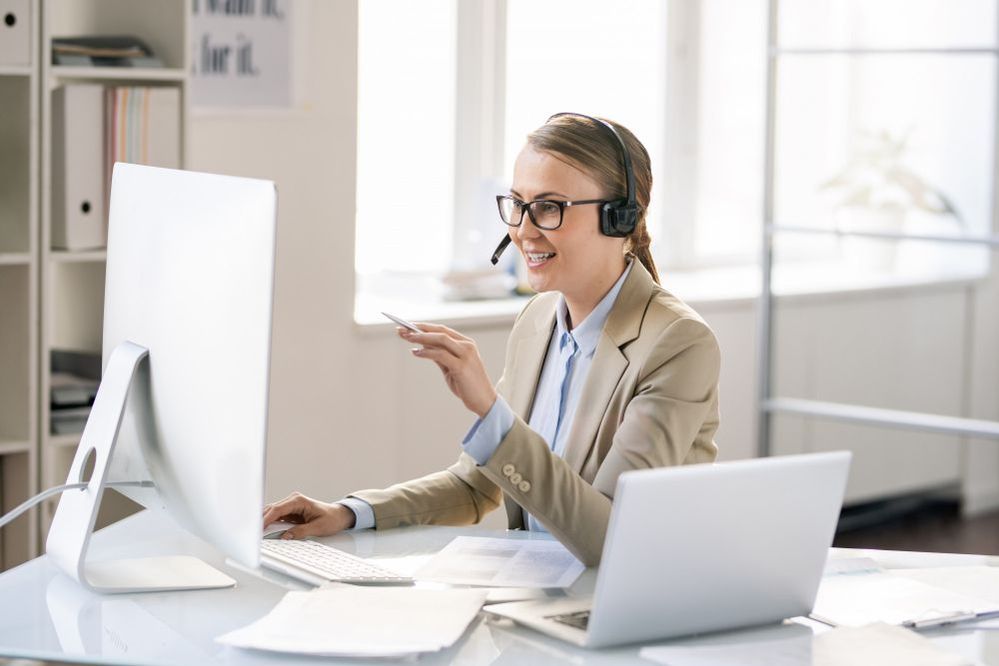 USADA - cheerful-friendly-young-female-call-center-representative-headset-with-microphone-sitting-table-using-computer-while-solving-technical-problem-clients.jpg